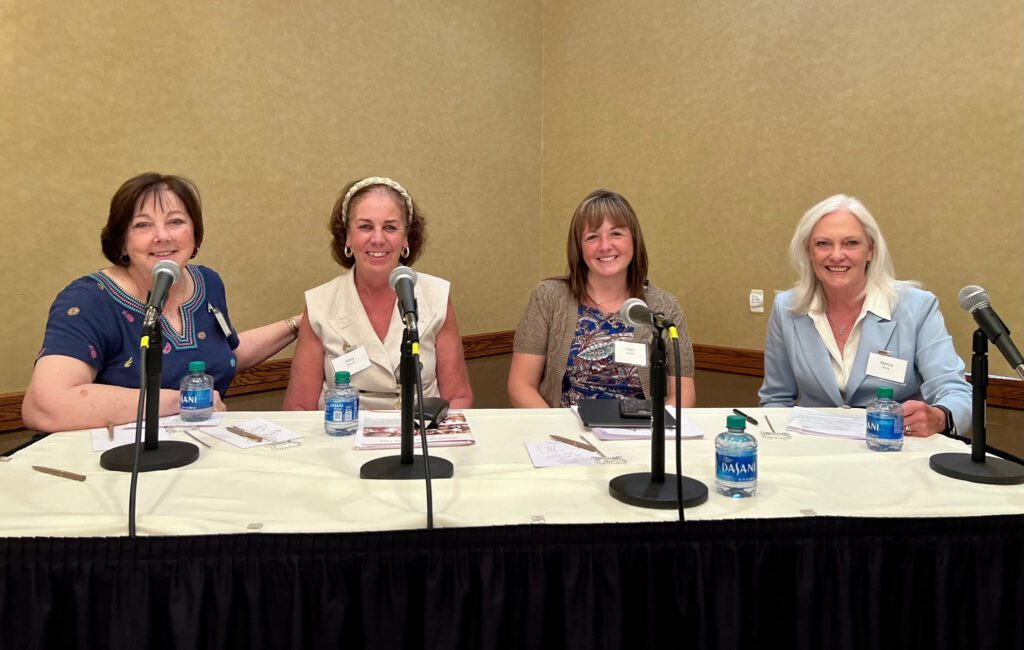 Four panelists seated at a table with microphones during an ANOHC panel discussion.