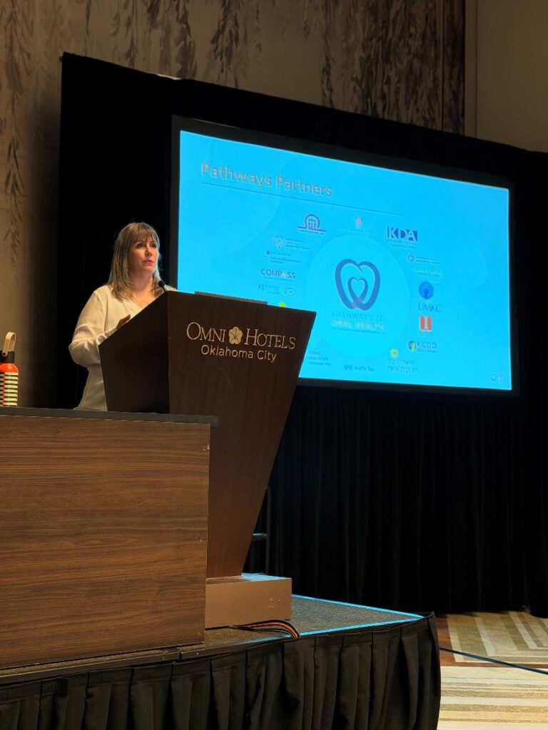Tanya Dorf Brunner presents at a podium during an oral health conference session.